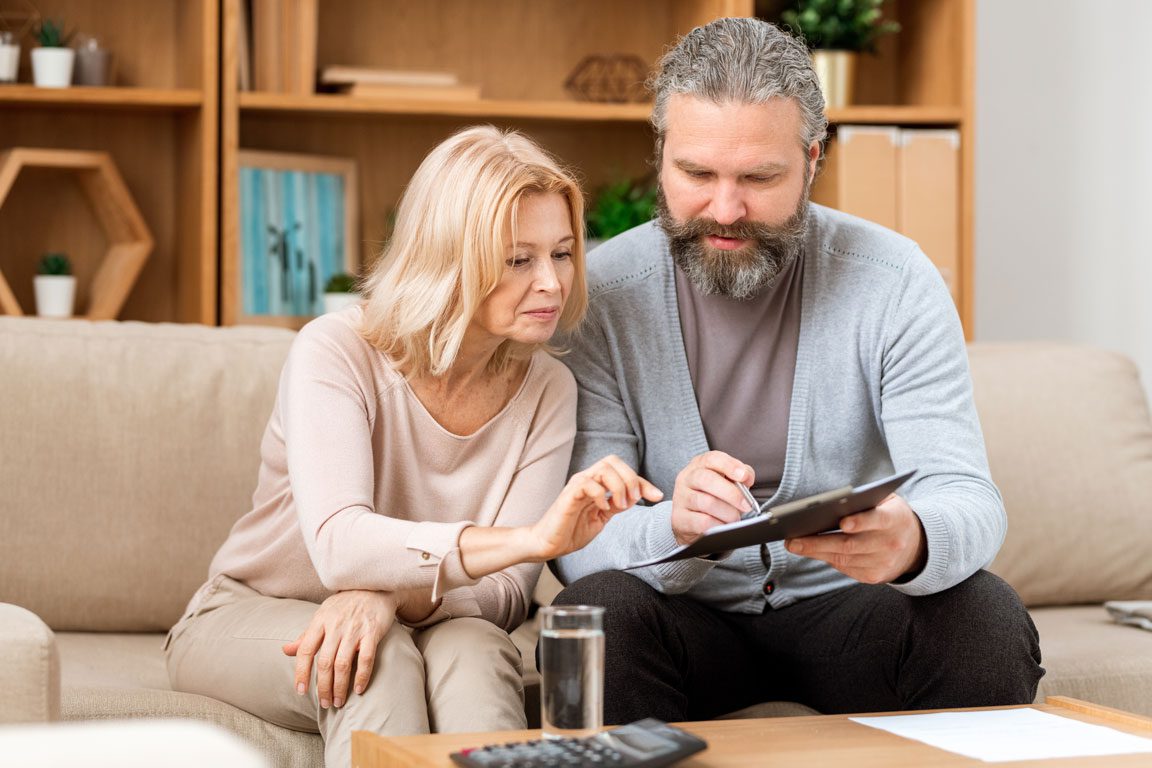 husband and wife signing forms on couch