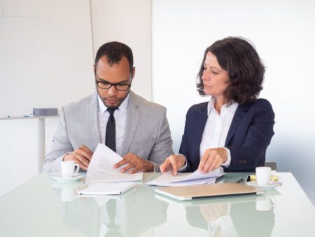 man and woman signing documents at a table